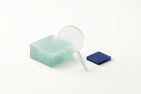A frosted glass lens between a stack of mint glass slabs and a navy sign-off tile